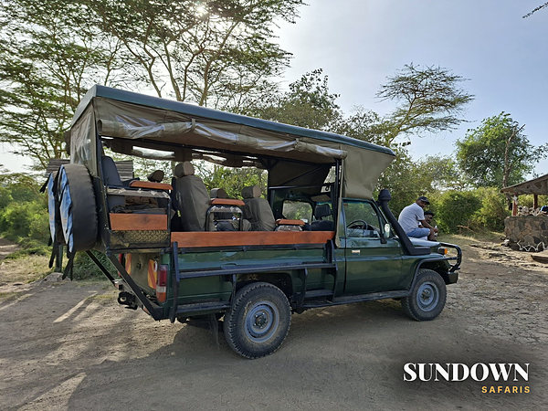 Open safari Land Cruiser parked at a picnic stop in the bush