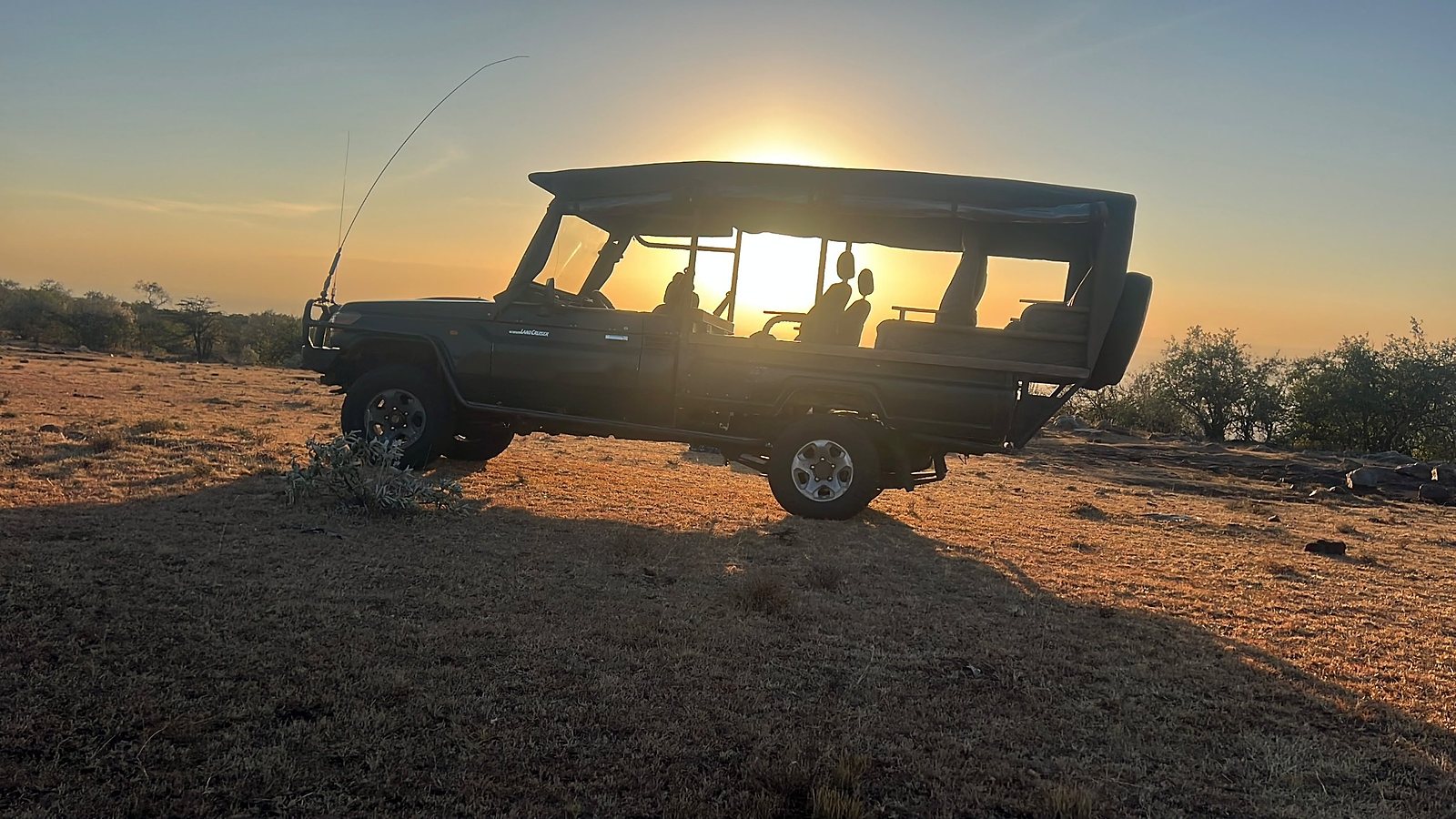 Sundown Safaris Land Cruiser silhouetted against the sunset on a Kenya game drive