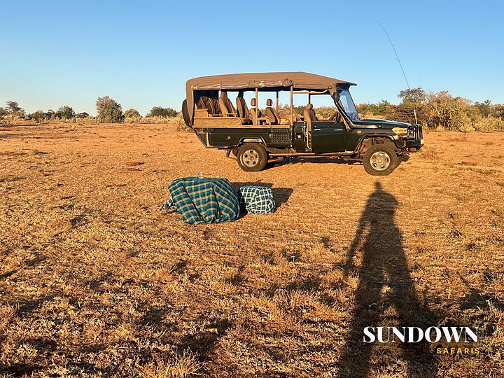 Sundowner blankets laid out beside our Land Cruiser on the plains