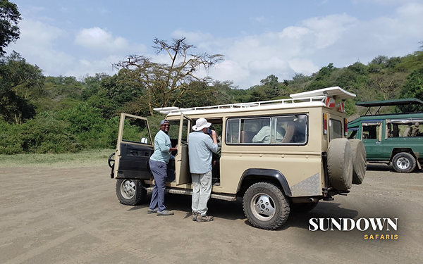 Sundown guide with guests beside the safari vehicle, Voyager 7 day private safari